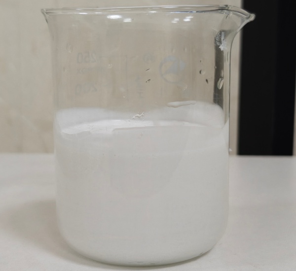 3900B-14 concentrated Boron Nitride release agent in a laboratory beaker, showing milky white inorganic formulation for high-temperature forging.