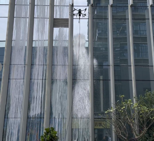 Specialized drone spraying WG200-H1 cleaning agent on high-rise glass curtain walls
